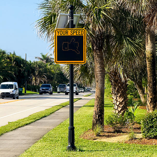 Road traffic direction sign to Bareboot beach park in Bonita Springs, Florida at Gulf of Mexico coast in summer with palm trees