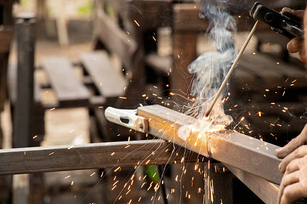 istock Welding metal parts with sparks and smoke - welder's work process, welding work 2220200237