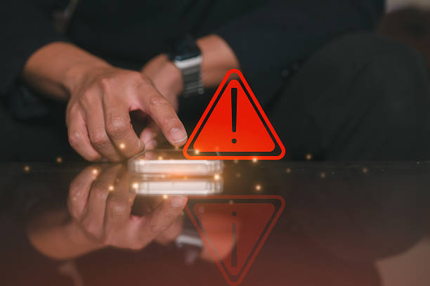 istock risk and cyber security technology concept, a man pointing at mobile phone with alert warning triangle sign showing to be careful with fraudulent Abort connection internet security 2220202336