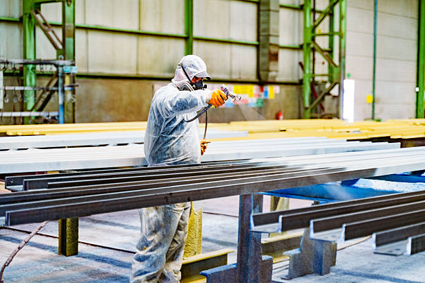 istock A painter is painting a steel surface white 2220202794