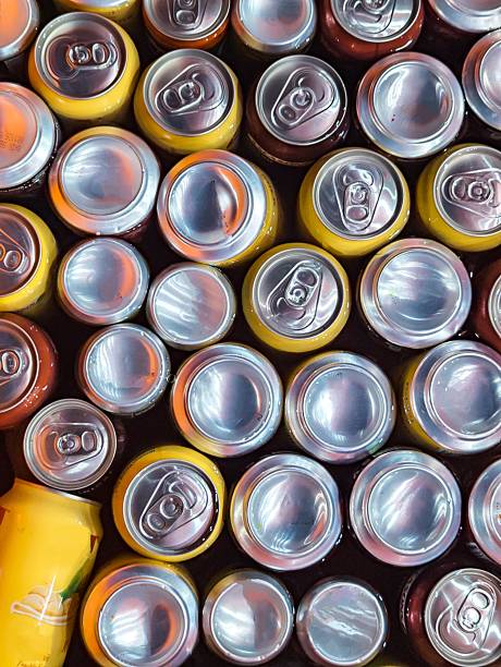 The background of the picture appears to be a dark, possibly liquid or submerged, surface where the aluminum cans are resting.
