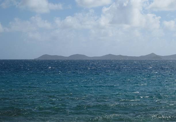 Tropical Seascape with Ocean Waves and Distant Green Islands under Blue Sky