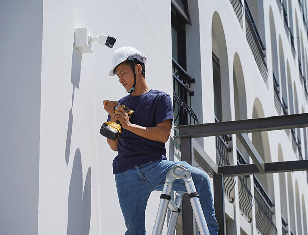 istock A technician installs a CCTV camera on the facade of a residential building 2220206049