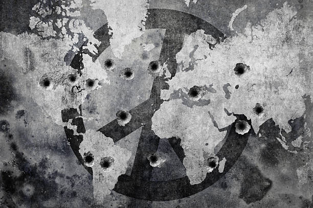 Bullet-riddled peace symbol overlaid on world map in black and white monochrome wall