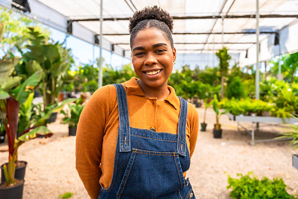 istock Young female worker smiling in greenhouse 2220209516