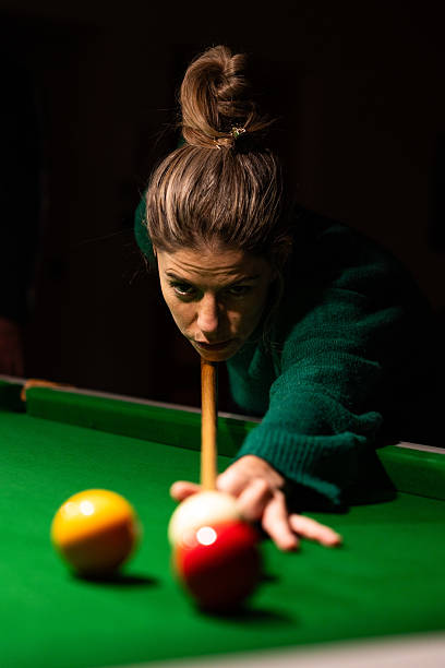 istock Young woman playing billiards with concentration and precision 2220209685