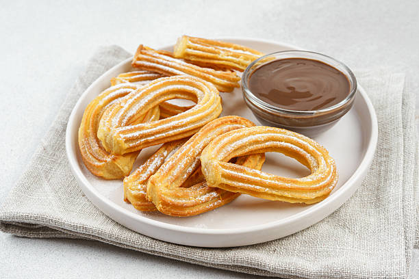 istock Traditional spanish dessert churros, fried dough pastry and chocolate sause on white background 2220210222