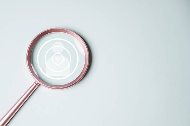 istock customer engagement target. target audience market. audience customer. A magnifying glass is on a white background with a circle in the middle. The circle is surrounded by smaller circles. 2220214874