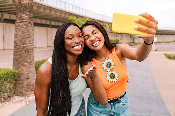 istock Two cheerful multiethnic women having fun taking a selfie with a smartphone on a sunny day 2220217381