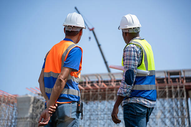 istock Civil Engineers in Safety Gear at Industrial Building Site, Construction Workers Planning Infrastructure Development, Engineers Discussing Project Progress at Construction Site 2220218160