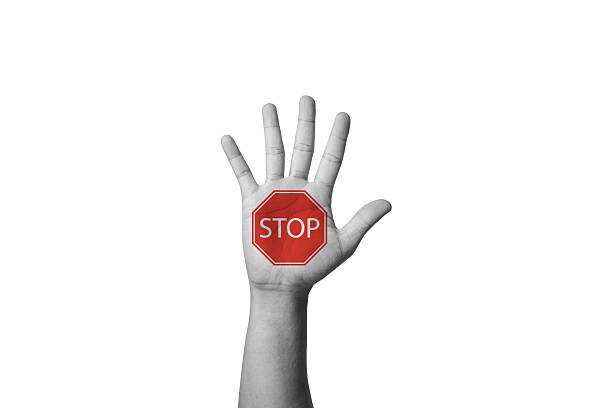 Businessman holding up hand with red stop on gesture and copy space.