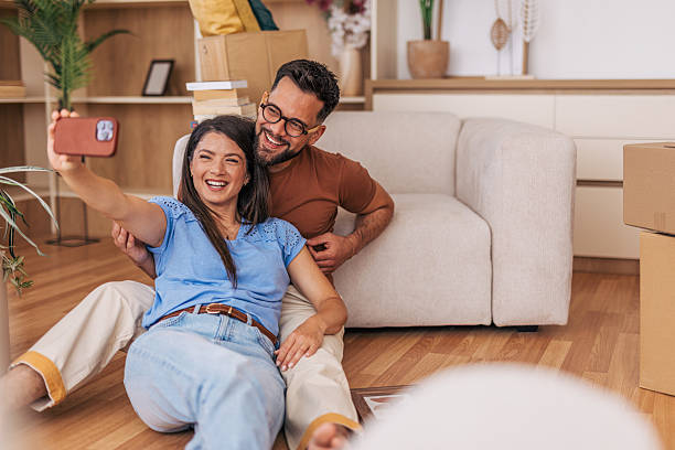 istock Happy couple taking a selfie while moving into new home 2220219078