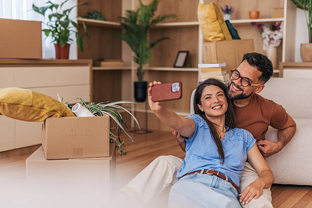 istock Happy couple taking a selfie while moving into new home 2220219102