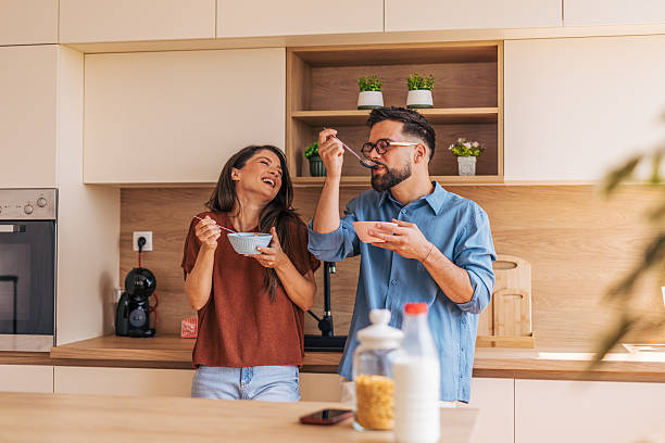 istock Cheerful couple enjoying breakfast together in modern kitchen 2220219272