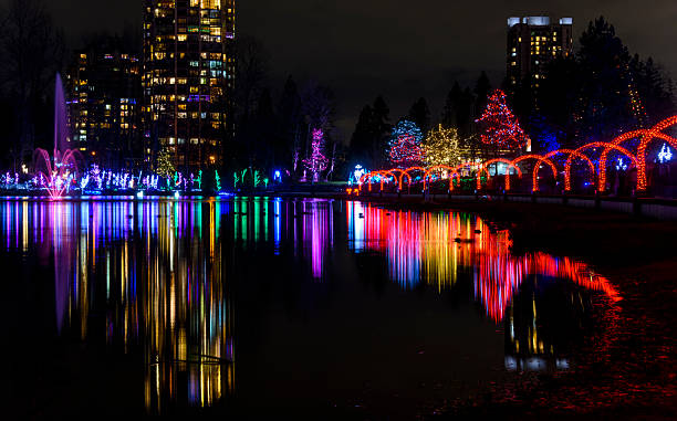 istock Colorful lights illuminate a park at night, creating reflections on the calm water surface 2220223534
