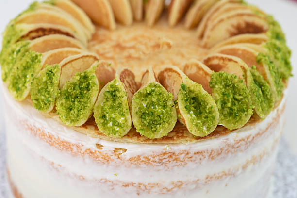 istock Layered moist cake with white frosting, topped with mini pancakes isolated on white background closeup side view of unique dessert 2220224620