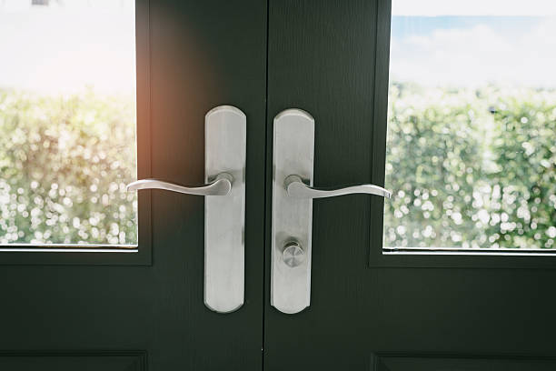 istock Modern Door Handles on Glass Doors with Greenery in Background Natural Light 2220226041
