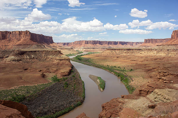 istock Majestic river flowing through canyon landscape under a bright blue sky with fluffy clouds 2220226830
