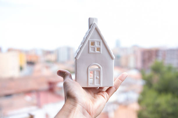 Young brunette showing a house miniature in her office