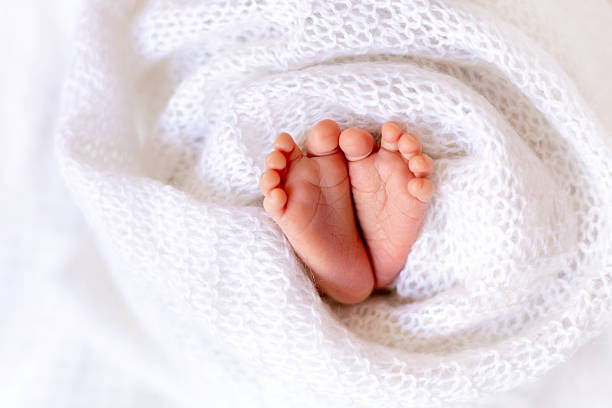 istock baby's feet on a white blanket or background, a place for text 2220235103