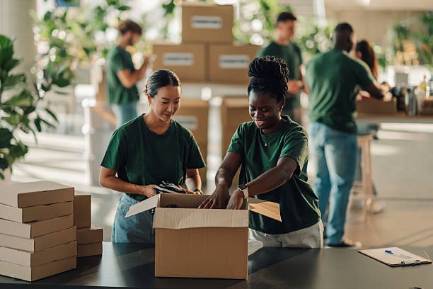 istock Volunteers packing clothes for donation in cardboard boxes 2220243173