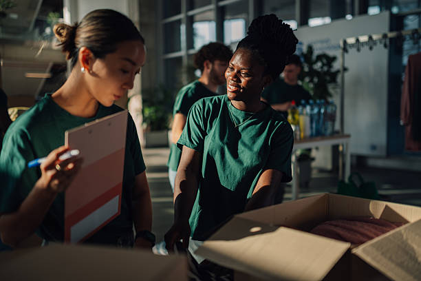 istock Volunteers preparing clothes donations for charity in cardboard boxes 2220243285