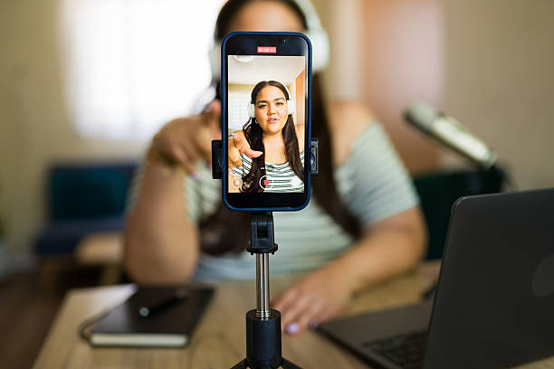 istock Influencer recording content with smartphone on tripod at home 2220253288
