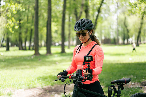 istock Cyclist vlogger preparing camera for mountain biking adventure in park 2220254359
