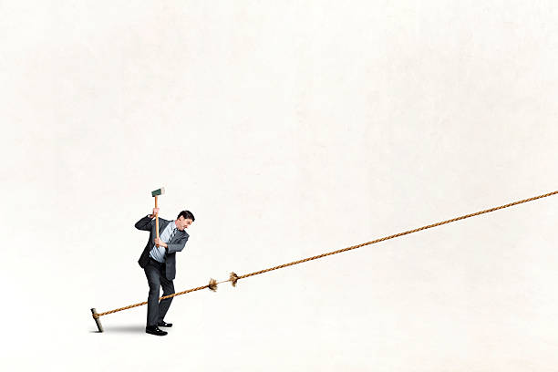 istock Man Uses Axe To Cut Long Piece Of Rope 2220259152