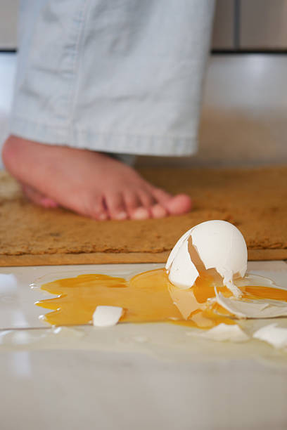 istock Egg spills on kitchen floor near bare foot at home in morning 2220262708