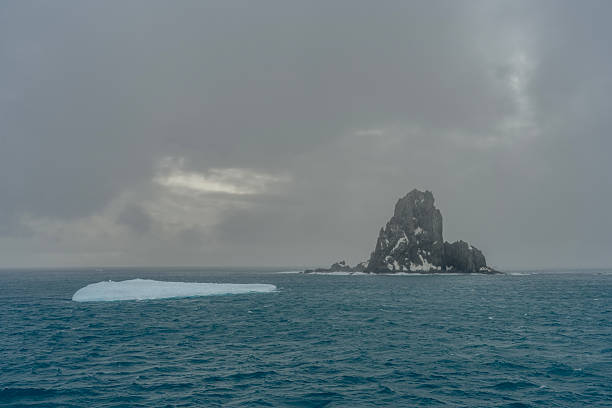 An Antarctic landscape shot near Cuverville island, highlighting mountains and icebergs.