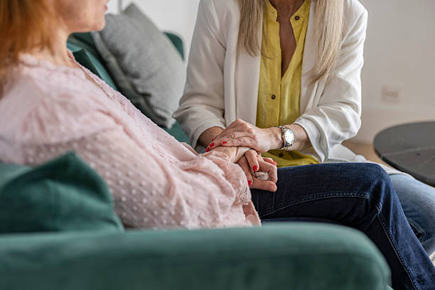 istock Psychologist comforting her patient by holding her hands during therapy session 2220264724