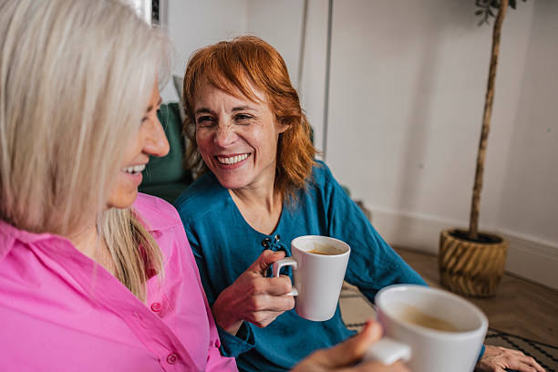 istock Senior women smiling and drinking coffee at home 2220264735