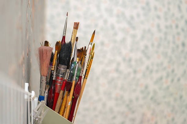 istock Assorted paintbrushes for artwork stored in a wall-mounted holder, showcasing an artist's creative tools 2220265345