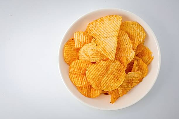 istock Potato chips in white plate on white  background 2220266411