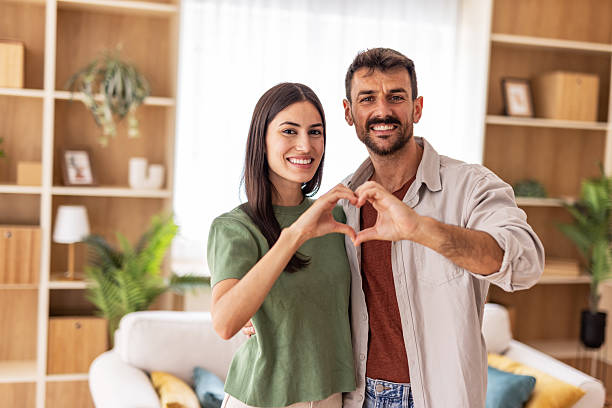 istock Happy couple making heart shape with hands at home 2220267090
