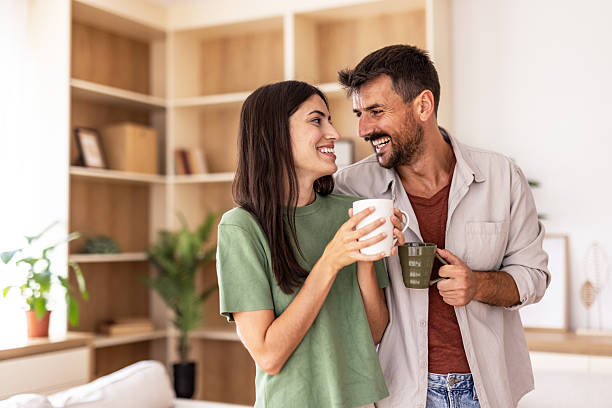 istock Happy couple smiling and drinking coffee at home 2220267157