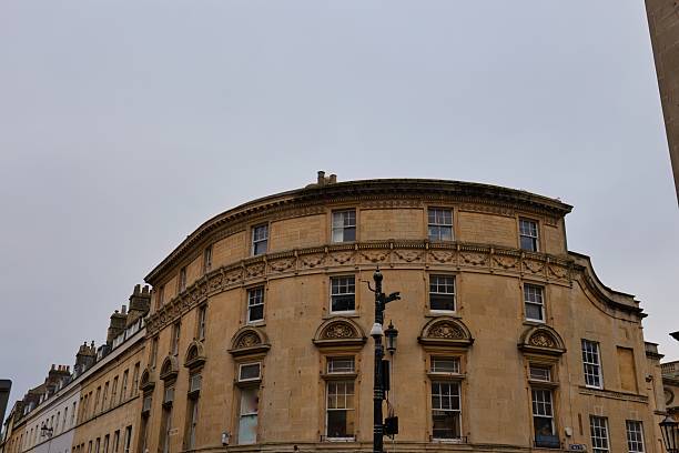 istock A beige building with a curved top and many windows stands under a cloudy sky. 2220267164