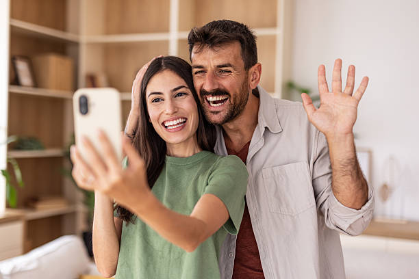 istock Happy couple making video call with smartphone at home 2220267212