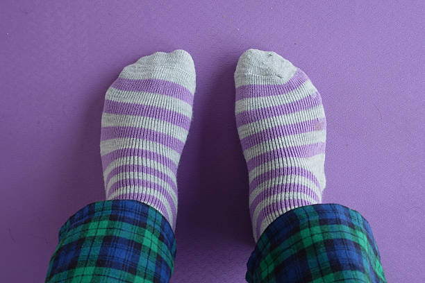 istock Cozy striped socks on a purple floor with plaid pants 2220268446