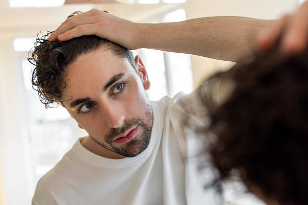 istock Man checking his hair in front of mirror 2220270812