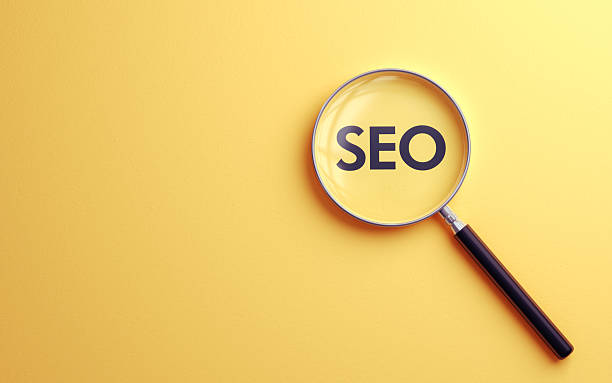 istock Seo Text Selected with Metallic Magnifying Glass on Soft Yellow Background 2220272801