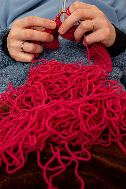 istock Woman hands knitting with a crochet hook and red thread , soft focus close up 2220273423