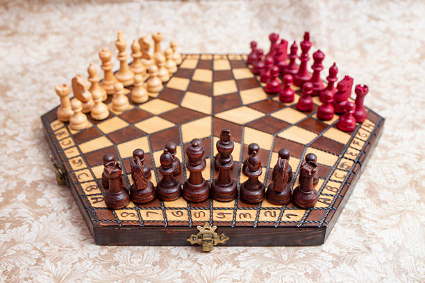 istock Three player chess board with black, white and red color pieces, on hexagonal shaped wooden board 2220274164