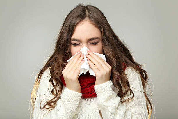 istock Sick young girl with handkerchief on grey background 2220274663