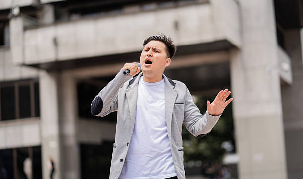 istock Urban singer performing outdoors in front of modern building. 2220278010