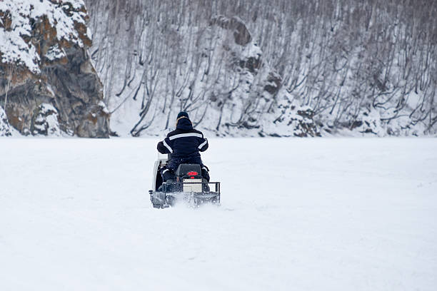 istock A man is riding a snowmobile on a snowy road 2220280487