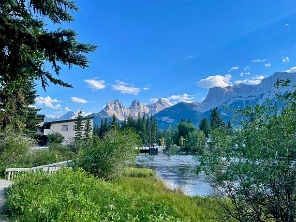 View of the Three Sisters peaks in the Canadian Rockies from a boardwalk across Spring Creek in Canmore, Alberta, Canada.