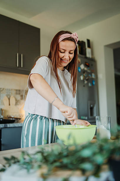 istock Young caucasian woman making bread dough in her kitchen 2220285547