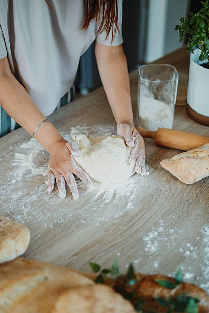 istock Young caucasian woman making bread dough in her kitchen 2220285581